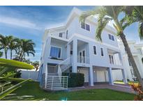 This two-story home features a modern design, multiple balconies, and manicured landscaping at 11105 5Th E St, Treasure Island, FL 33706