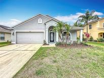 Charming single-Gathering home featuring a two-car garage and well-maintained lawn with mature palm trees at 11414 Weston Course Loop, Riverview, FL 33579