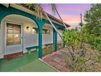 Inviting front porch features arched supports, bench seating and colorful accents at 11705 Ibis Ln, Port Richey, FL 34668
