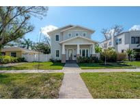 Charming two-story home with a manicured lawn and inviting brick walkway on a sunny day at 1550 48Th N Ave, St Petersburg, FL 33703