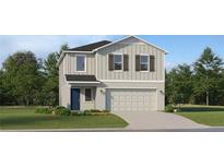 Charming two-story home featuring a two-car garage, landscaped front yard, and classic architectural details at 2287 Blue Grosbeak Pl, Wimauma, FL 33598