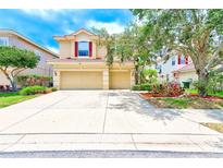 Inviting two-story home with a three-car garage, red shutters, and a well-manicured lawn at 2300 Hannah S Way, Dunedin, FL 34698