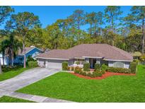 Charming single-story home with lush green lawn and mature trees in a quiet neighborhood at 3109 Tarpon Woods Blvd, Palm Harbor, FL 34685