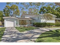Charming single-Gathering home with well-manicured lawn, mature trees, and a driveway at 4417 W Fair Oaks Ave, Tampa, FL 33611