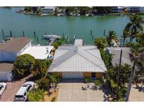 Waterfront home with boat dock and lift, lush landscaping, and a large driveway for multiple cars at 14043 E Parsley Dr, Madeira Beach, FL 33708