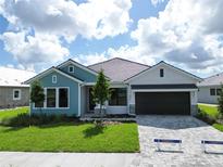 Charming single-story home with a well-manicured lawn, brick driveway, and attached two-car garage at 18051 Foxtail Loop, Venice, FL 34293
