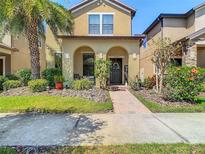 Charming two-story home with a beautifully landscaped front yard and covered entryway at 28642 Tranquil Lake Cir, Wesley Chapel, FL 33543