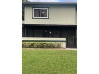 View of front exterior with screened in porch and green lawn at 2910 Lichen Ln # B, Clearwater, FL 33760