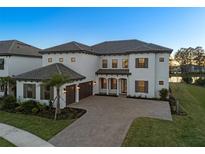 Stunning two-story home featuring a tile roof, large windows, and a spacious driveway with a two-car garage at 33736 Ocean Spray Ln, Wesley Chapel, FL 33543