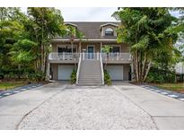 Charming two-story home with a spacious porch, two-car garage, and lush, tropical landscaping at 758 Claudia Ln, Palm Harbor, FL 34683