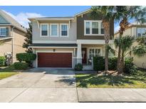 Two-story home with a two-car garage, beautifully landscaped yard, and charming front porch at 7606 S Sparkman St, Tampa, FL 33616