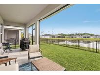 Spacious backyard featuring a patio, lush lawn, and serene water views at 8706 Arrow Creek Dr, Parrish, FL 34219