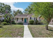 Charming bungalow with a manicured lawn and a inviting walkway leading to the front door at 933 E Shadowlawn Ave, Tampa, FL 33603