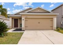 Charming single-story home featuring a two-car garage and well-maintained lawn in a desirable neighborhood at 14426 Haddon Mist Dr, Wimauma, FL 33598