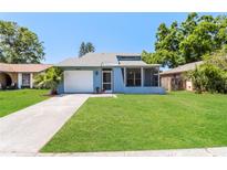 Charming single-story home with a well-maintained lawn and a screened porch at 16012 Ballica Dr, Tampa, FL 33618