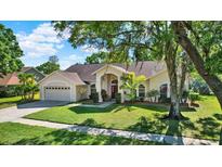 Charming single-story home with manicured lawn, mature trees, and attached two car garage at 17108 Longacres Ln, Odessa, FL 33556