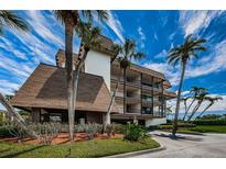 Three-story condo building has a brown roof, carports and palm trees at 3021 Countryside Blvd # 24A, Clearwater, FL 33761