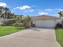 Well maintained single-story home with a wide driveway, lush landscaping and a two car garage at 3323 Ringwood Mdw, Sarasota, FL 34235