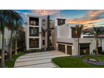 Stunning modern home featuring multiple balconies and a well-manicured front yard at sunset at 5131 W Neptune Way, Tampa, FL 33609