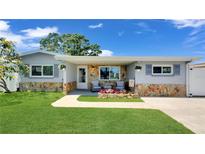 Charming single-story home featuring a beautifully landscaped front yard and stone facade at 5248 Coral N Way, St Petersburg, FL 33714