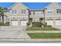 Well-maintained townhouse with attached garage and landscaped front yard on a bright, sunny day at 542 Black Lion Ne Dr, St Petersburg, FL 33716