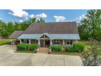 Inviting single-story home with a covered porch and meticulously maintained landscaping at 6448 Country Club Rd, Wesley Chapel, FL 33544