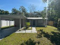 Charming single-story home featuring a carport, walkway lights, and a well-maintained front lawn at 7106 S Sparkman St, Tampa, FL 33616