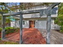 Inviting home with a covered entrance, brick patio, attached garage, and prominent house number at 8420 Orient Ne Way, St Petersburg, FL 33702