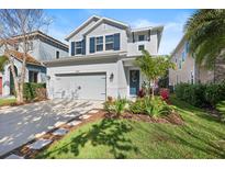 Charming two-story home with a manicured lawn, tidy landscaping and a gray painted garage at 14241 Natures Reserve Dr, Lithia, FL 33547