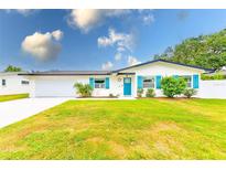 Charming one story home with colorful shutters, landscaped yard, and a white exterior at 1851 Glenville Dr, Clearwater, FL 33765