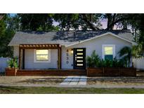 Charming single-story home with a modern black door and inviting wooden porch at 4530 5Th S Ave, St Petersburg, FL 33711