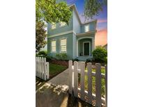 Charming two-story home featuring a picket fence, inviting entrance and lush landscaping at 6111 Hadley Commons Dr, Riverview, FL 33578