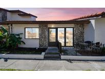Inviting villa featuring a charming brick facade, tiled roof, and a cozy front patio area at 7360 Ulmerton Rd # 29B, Largo, FL 33771