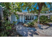 Charming single-story home with mature landscaping and a brick walkway leading to the front door at 810 Lantana Ave, Clearwater Beach, FL 33767