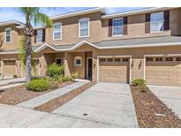 Charming townhouse with an attached garage, well-manicured lawn, and lovely front yard landscaping at 10418 Tulip Field Way, Riverview, FL 33578