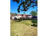Charming one-story home with a well-manicured front lawn, lovely landscaping, and a two-car garage at 1061 6Th Nw St, Largo, FL 33770
