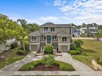 Stunning home featuring a beautiful, symmetrical facade, manicured landscaping, and a circular driveway at 2050 N Pointe Alexis Dr, Tarpon Springs, FL 34689
