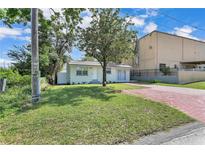 Charming home with a green lawn and a brick driveway, offering a welcoming curb appeal at 2107 E 93Rd Ave, Tampa, FL 33612