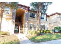 Inviting condo exterior with stone accents, well-maintained landscaping, and an inviting stairwell at 2220 Chianti Pl # 8-0817, Palm Harbor, FL 34683