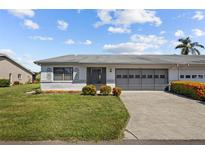 Charming single-story home with well-maintained landscaping, driveway and a large garage door at 2411 Lancaster Dr, Sun City Center, FL 33573