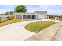 This home has a two-car garage and a charming blue front door at 3543 Rockaway Dr, Holiday, FL 34691