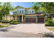Charming two-story home with a brick driveway, well-kept landscaping, and a spacious three-car garage at 10007 Hazelnut Ct, Tampa, FL 33647