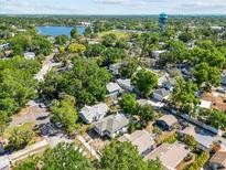 Aerial view of a quiet neighborhood with lush trees, a community lake, and a grassy field at 1115 Crescent Lake N Dr, St Petersburg, FL 33701