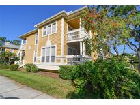 Charming multi-level home featuring a screened porch and balcony, surrounded by lush landscaping at 115 112Th Ne Ave # 1027, St Petersburg, FL 33716