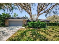 Charming brick home with a well-manicured lawn and mature trees in a peaceful setting at 11510 Moffat Pl, Temple Terrace, FL 33617