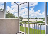 Balcony view overlooking serene lake with blue skies, screened in for peaceful enjoyment at 12170 Lake Allen Dr, Largo, FL 33773
