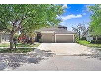 Charming home featuring a well-manicured lawn, mature trees, and a spacious three car garage at 15723 Starling Water Dr, Lithia, FL 33547