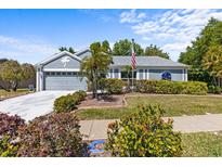 Charming home with mature landscaping, palm trees, and well-manicured lawn at 1700 Hunter Ln, Tarpon Springs, FL 34689