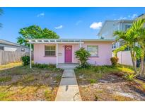 Charming single-story home featuring a vibrant pink exterior and well-lit front porch at 2827 1St Ne St, St Petersburg, FL 33704
