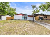 Charming single-Gathering home with modern exterior, carport, and well-maintained front yard at 10909 N Lantana Ave, Tampa, FL 33612